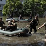Une femme est évacuée d'un quartier inondé à Kherson, dans le sud de l'Ukraine, après la destruction partielle du barrage de Kakhovka.